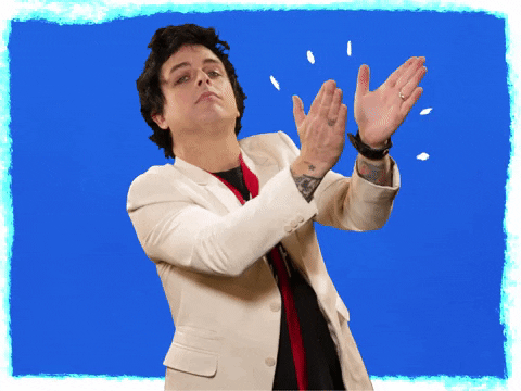 Billi Joe Armstrong clapping on a blue background
