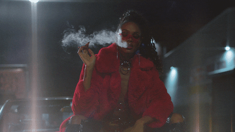 A woman in a red coat smoking