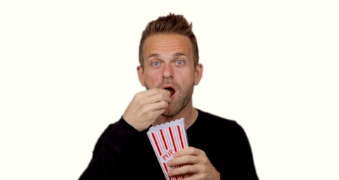 A man eating popcorn in a white background